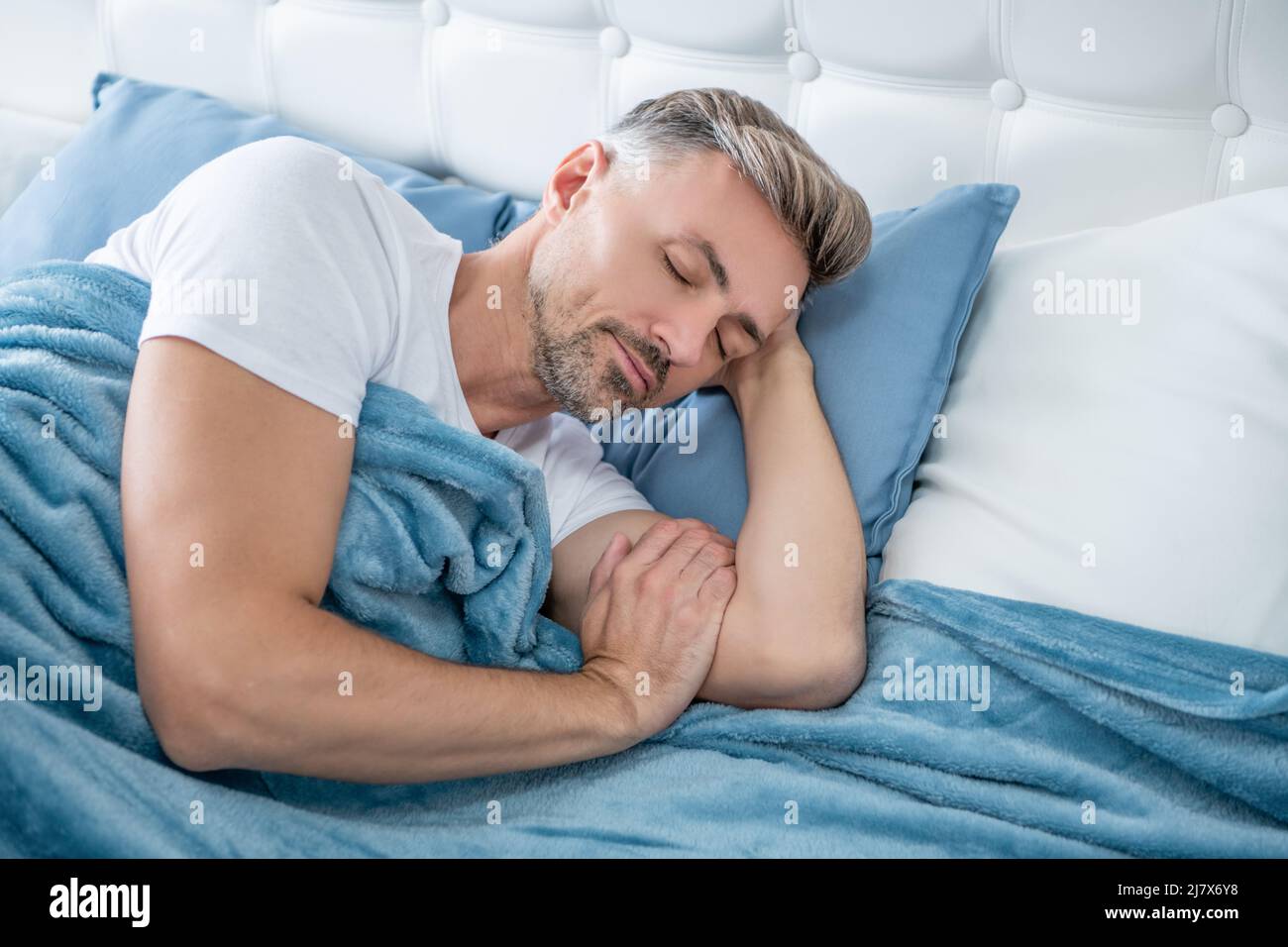 Grizzle Mann schläft im Bett. Am frühen Morgen Stockfoto