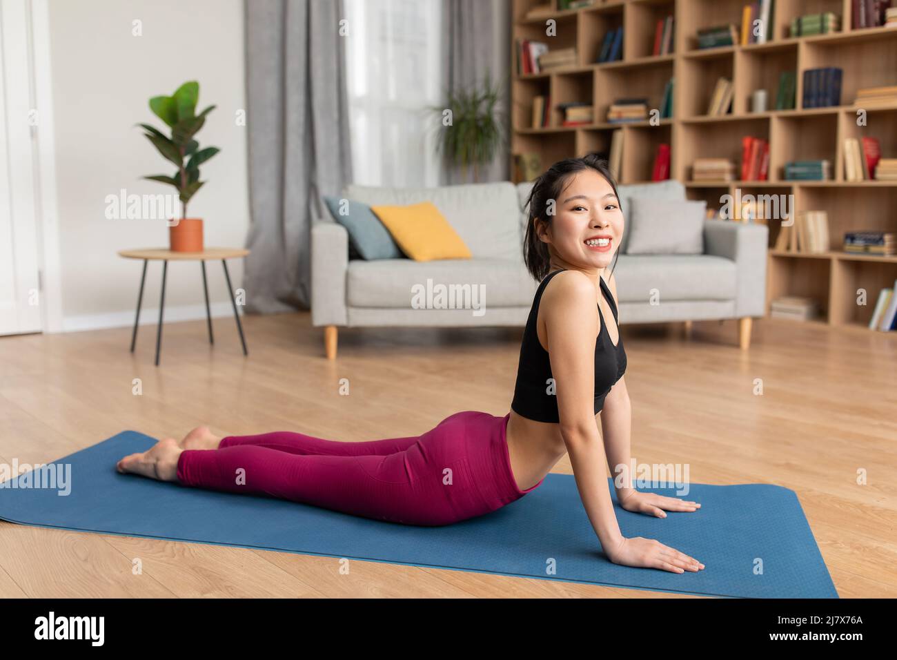 Linderung von Schmerzen im unteren Rücken. Fit asiatische Dame tun Sphinx Cobra Pose oder nach oben gerichtete Hund Asana, Dehnung der Rückenmuskeln Stockfoto