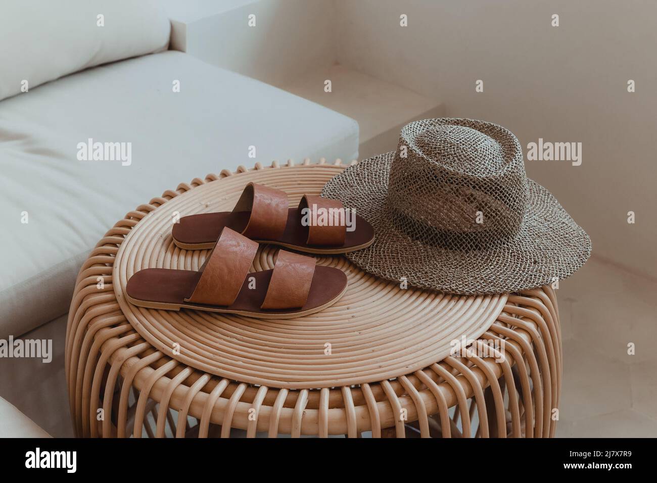 Braune Lederschuhe und ein Strohhut auf einem Holztisch Stockfoto