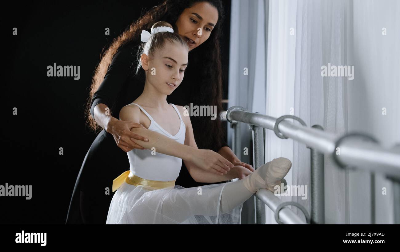 Weibliche Choreografin Lehrer Mentor Trainer des klassischen Tanzes lehrt Haltung Hilfe mit Stretching zu jungen Studenten lernen tanzen teen Mädchen Ballerina Stockfoto