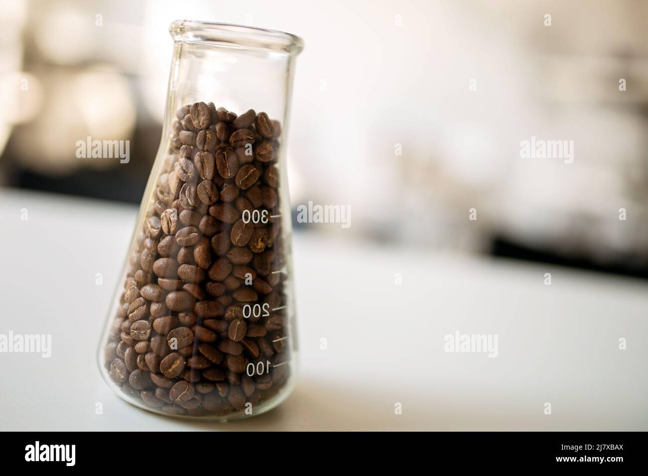 Dunkel geröstete Kaffeebohnen auf dem Tisch im Glas Stockfoto