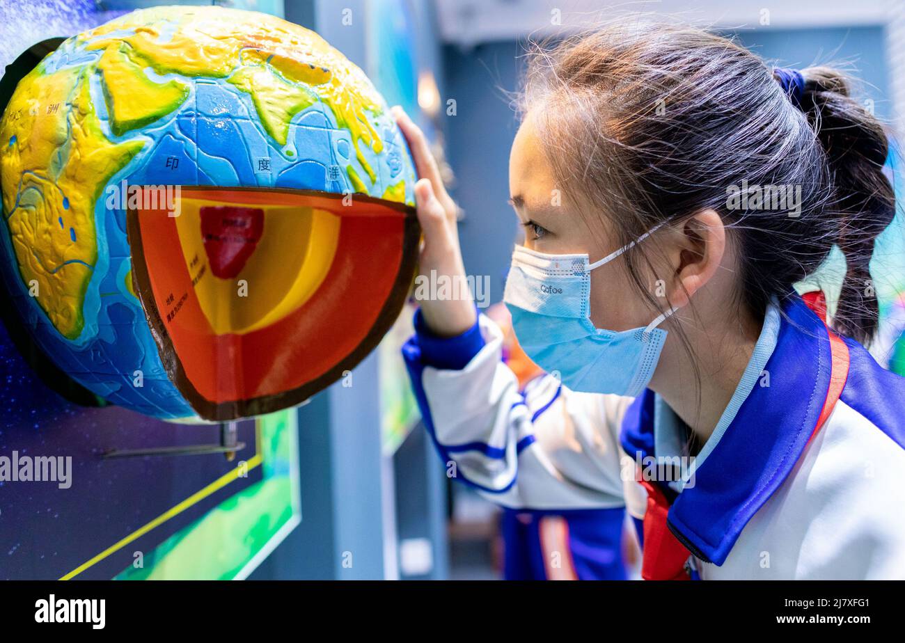 HOHHOT, CHINA - 11. MAI 2022 - Grundschüler lernen im Seismologischen Wissenschaftsmuseum anhand eines Modells die innere Struktur der Erde kennen Stockfoto