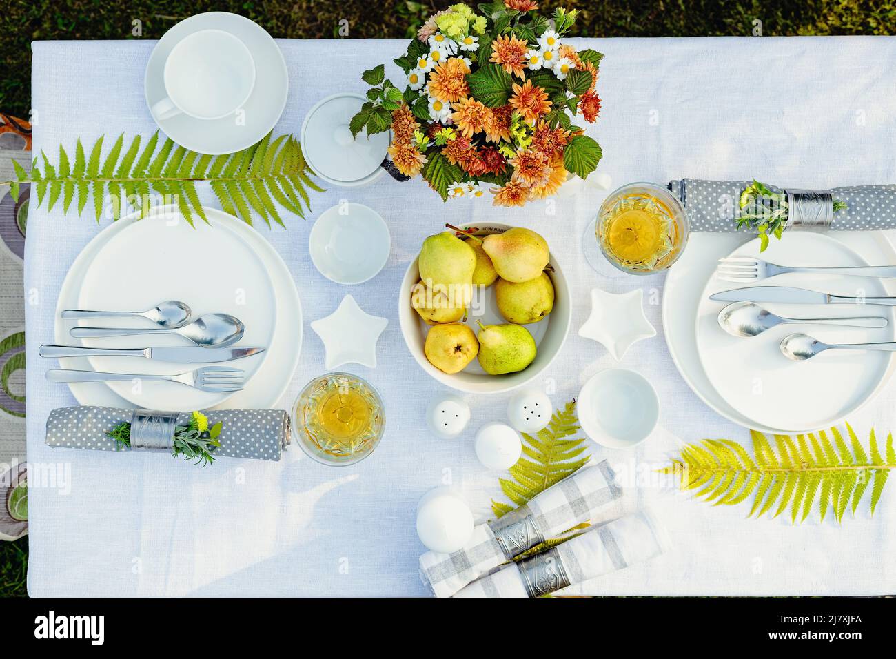 Sommerurlaub Tisch aufgestellt. Elegantes Tischdekett mit weißen Gerichten auf einer weißen Tischdecke. Obst, Getränke in Kristallgläsern. Tisch für out eingestellt Stockfoto