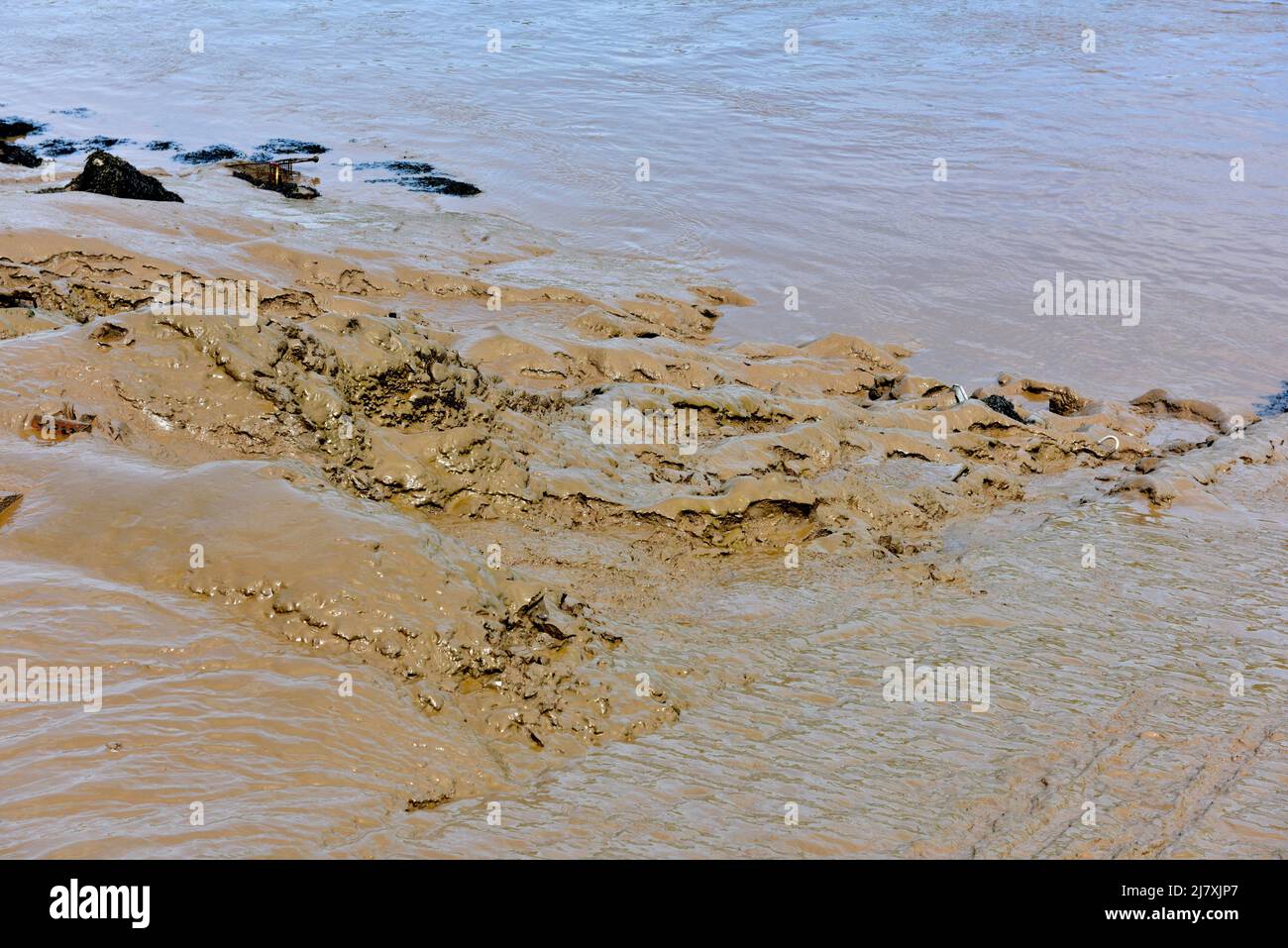 Abstrakter Hintergrund von feinem, nassem Schlamm bei Ebbe in der Mündung des Flussbettes Stockfoto