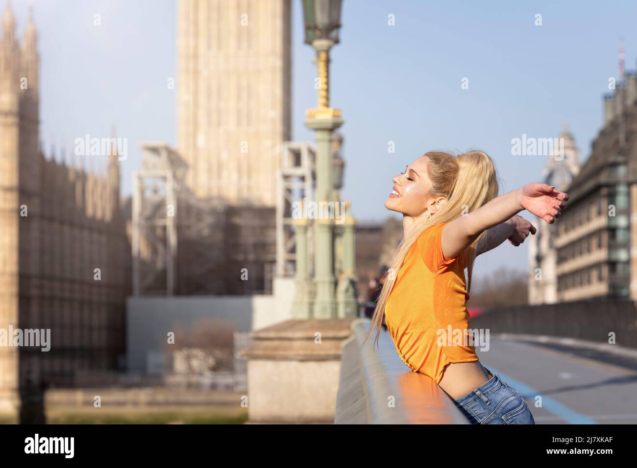 Eine glückliche Touristenfrau steht auf der Westminster Bridge in London Stockfoto