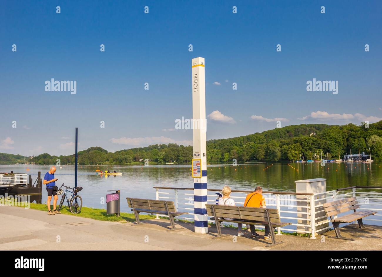 Menschen, die sich auf einer Bank am Bladeney-See in Bredeney, Essen, entspannen Stockfoto