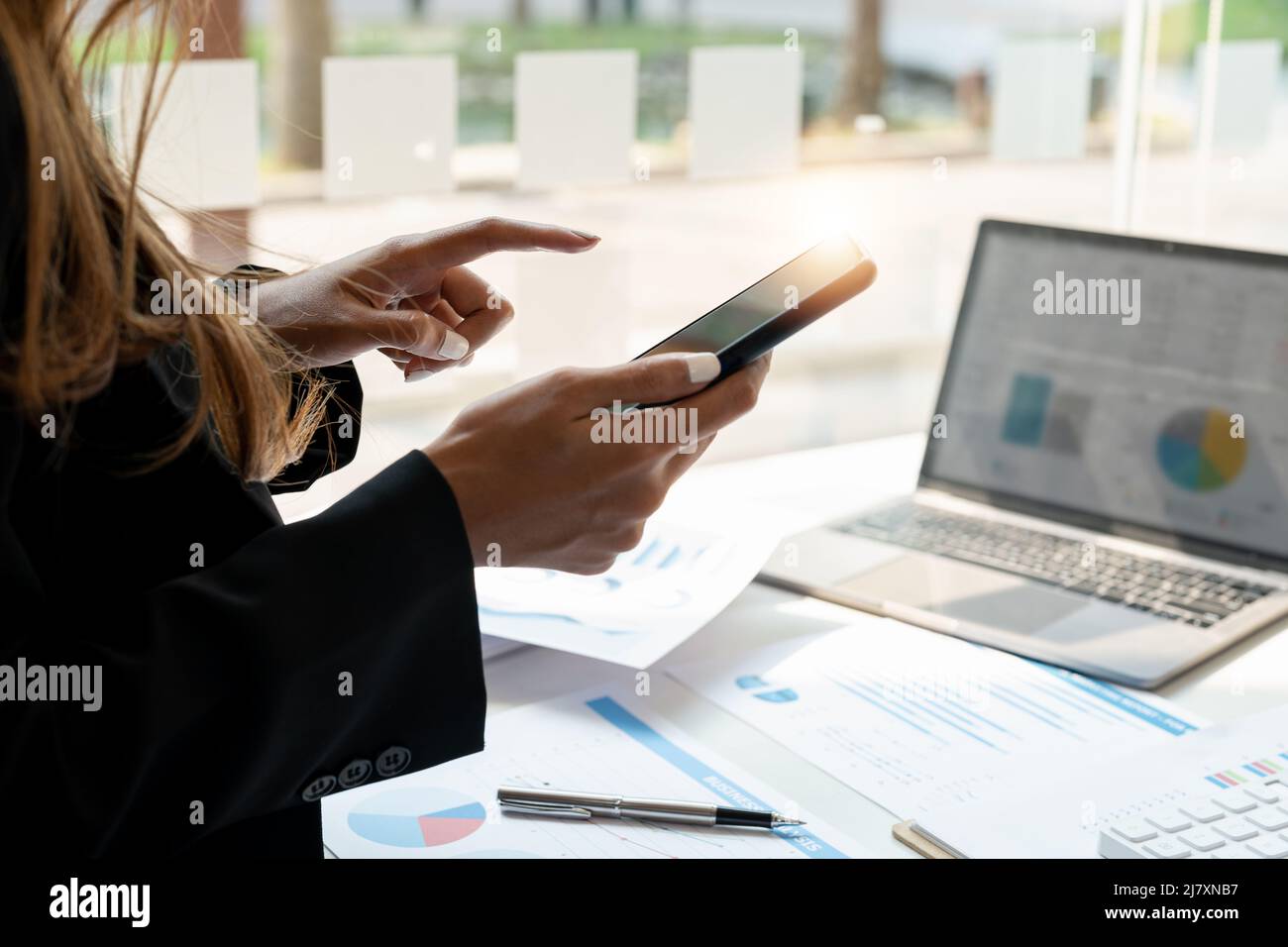 Nahaufnahme Geschäftsfrau Nutzung von Smartphone für die Finanzbuchhaltung im Büro Stockfoto