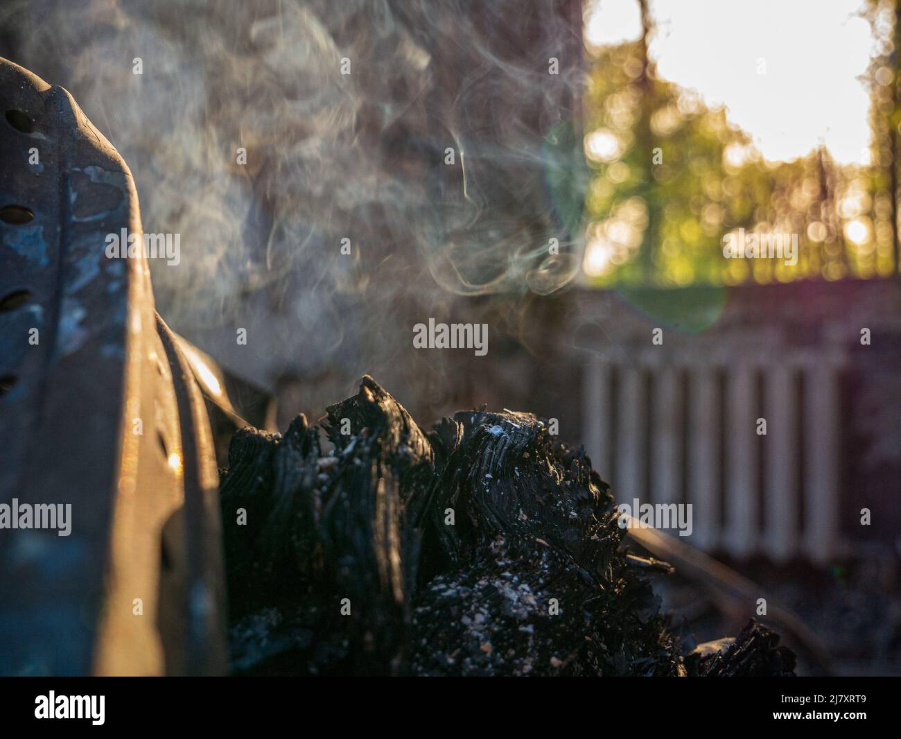 Charkiw Region, Charkow, Skovorodinovka, Skovorodinivka, Ukraine - 05.07.2022: Brennendes Schwelbrand rauchendes Stück Holzmetallfragmente zerstört Stockfoto