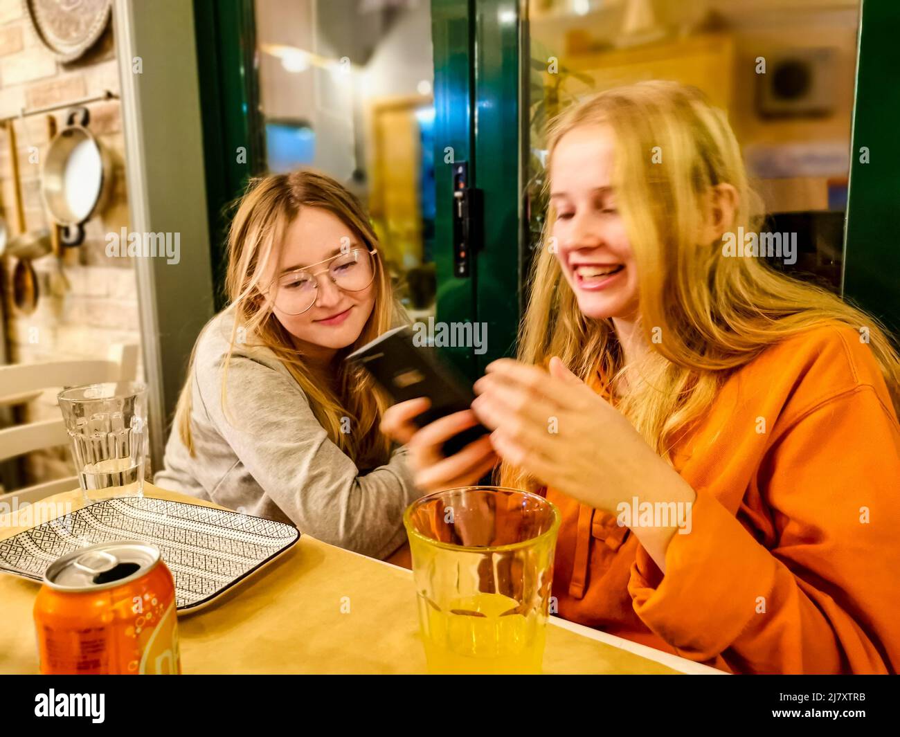 Zwei Schwestern haben Spaß beim Betrachtern eines Mobiltelefons Stockfoto