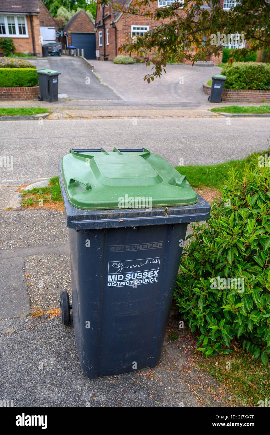 Grüne Behälter in Wohnstraße bereit zur Abholung. Stockfoto