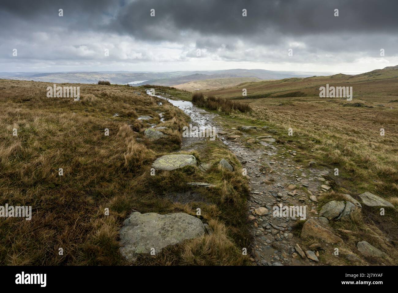 Der Fußweg von Goat’s Water zur Walna Scar Road bei Little Arrow Moor unterhalb des Old man of Coniston im Spätwinter im Lake District National Park, Cumbria, England. Stockfoto