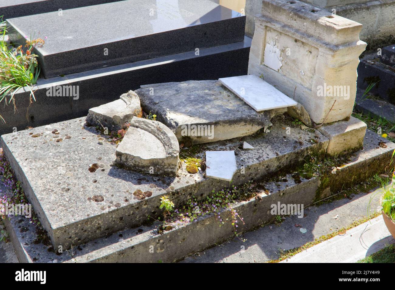 Eine feige, gnadenlose und unedle Aktion - Ein vandalisiertes und verletztes Grab auf dem Friedhof von Montparnasse - Paris Stockfoto