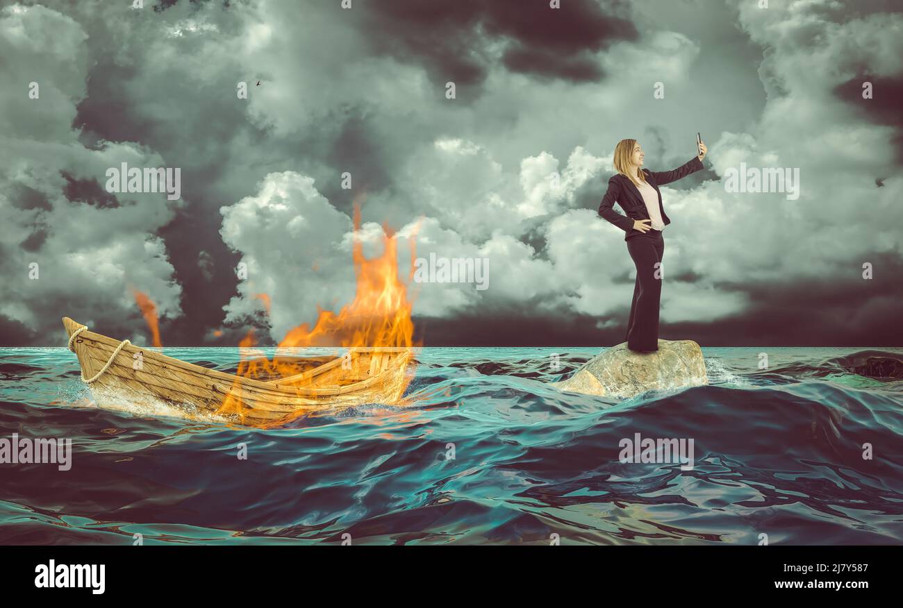 Schiffbrüchige Frau macht ein Selfie mit dem brennenden Boot Stockfoto