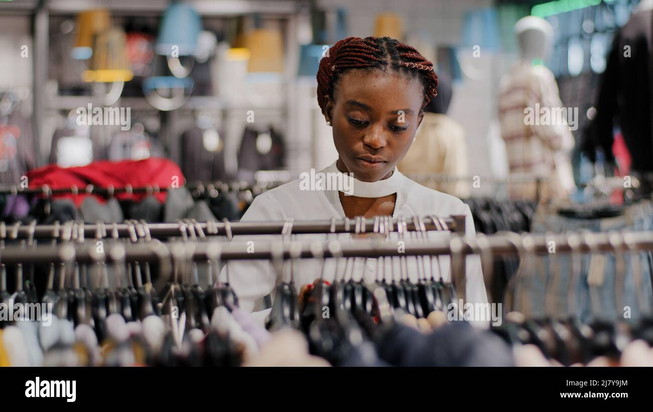 Allein glücklich afroamerikanischen Mädchen Millennial Frau Käufer Kunde Käufer stehen in Kleidung Shop Mall Auswahl trendy Kleider Waren weiblich Stockfoto