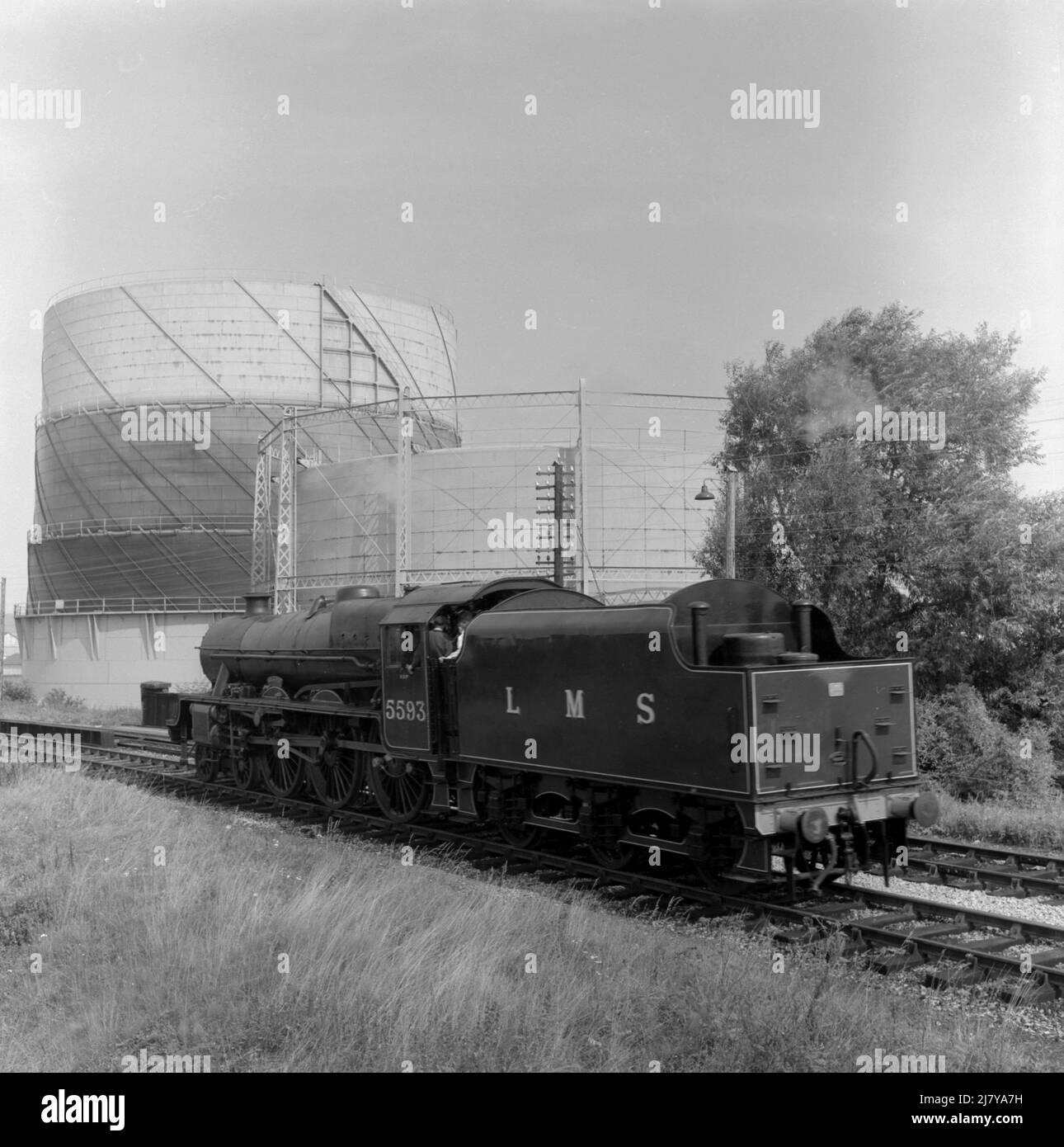 1969, historisch, Mann auf der Strecke im Gespräch mit den Fahrern der wartenden Dampflokomotive, KOLHAPUR 5593 LMS, England, Großbritannien. Erbaut 1934 von der North British Locomotive Company of Glasgow, wurde es 1936 nach Kolhapur in Westindien benannt. Stockfoto