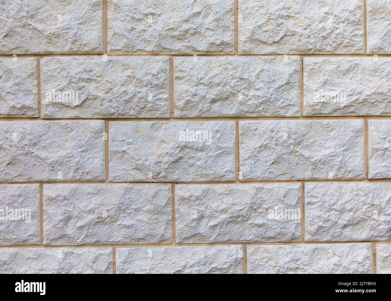 Vollformatbild der beigefarbenen Kalksteinwand. Für Hintergrund, Poster, Loft-Stil, Textur, viel Platz für Text. Stockfoto