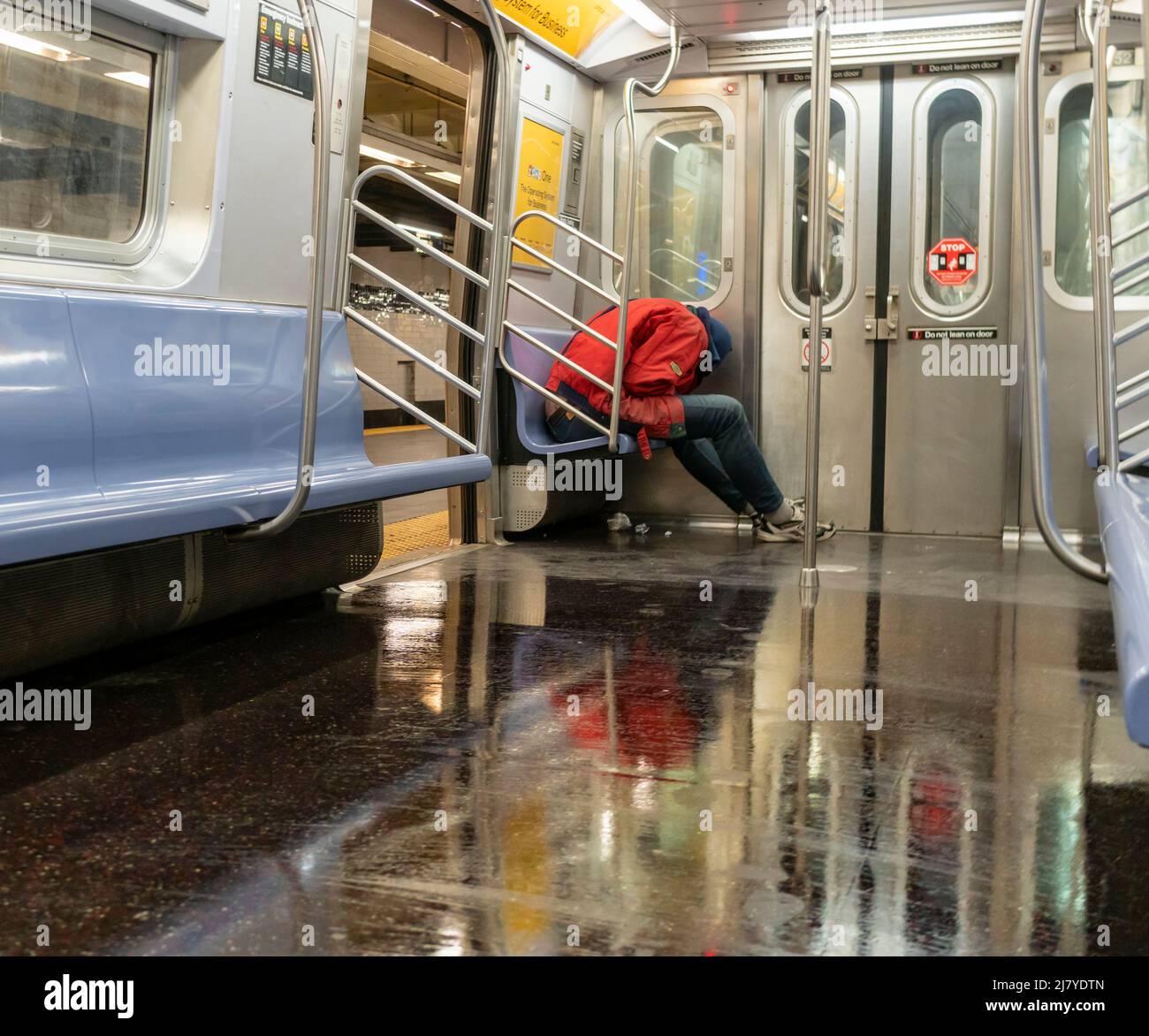 Ein Obdachloser schläft am Samstag, den 30. April 2022, in einem U-Bahn-Zug der E-Linie in New York. (© Richard B. Levine) Stockfoto