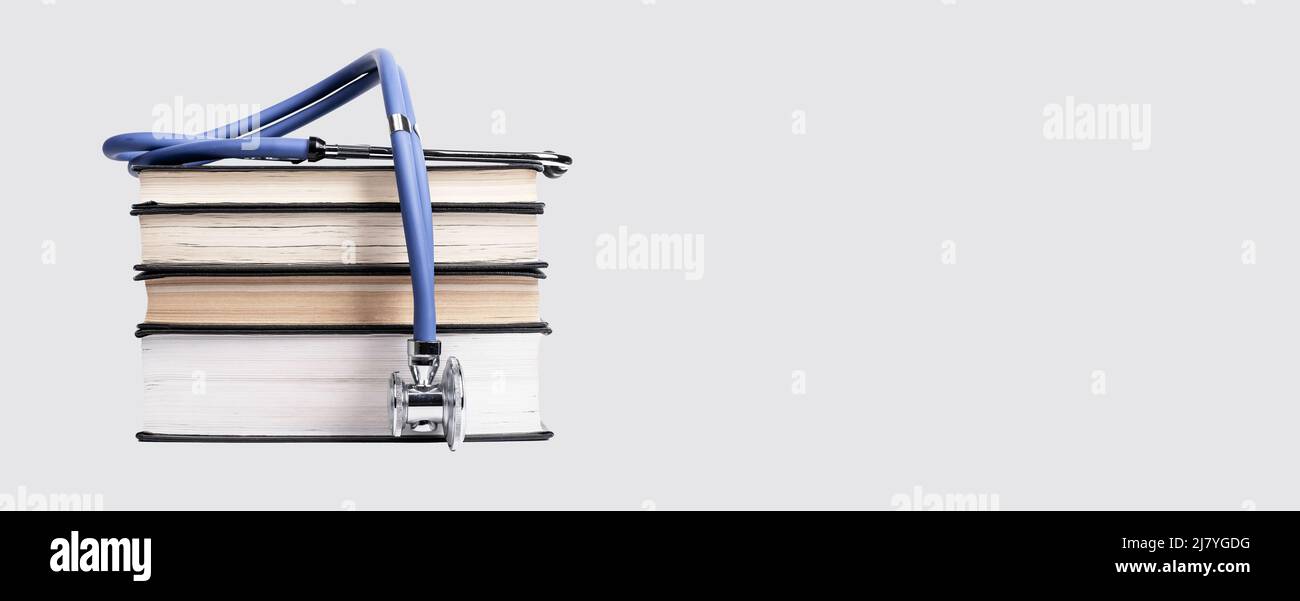 Banner mit medizinischem Bildungskonzept. Bücher stapeln mit Stethoskop. Medizinische Kenntnisse erhalten, Studie für den Arzt zu werden. Platz auf grauem Hintergrund kopieren. Hochwertige Fotos Stockfoto