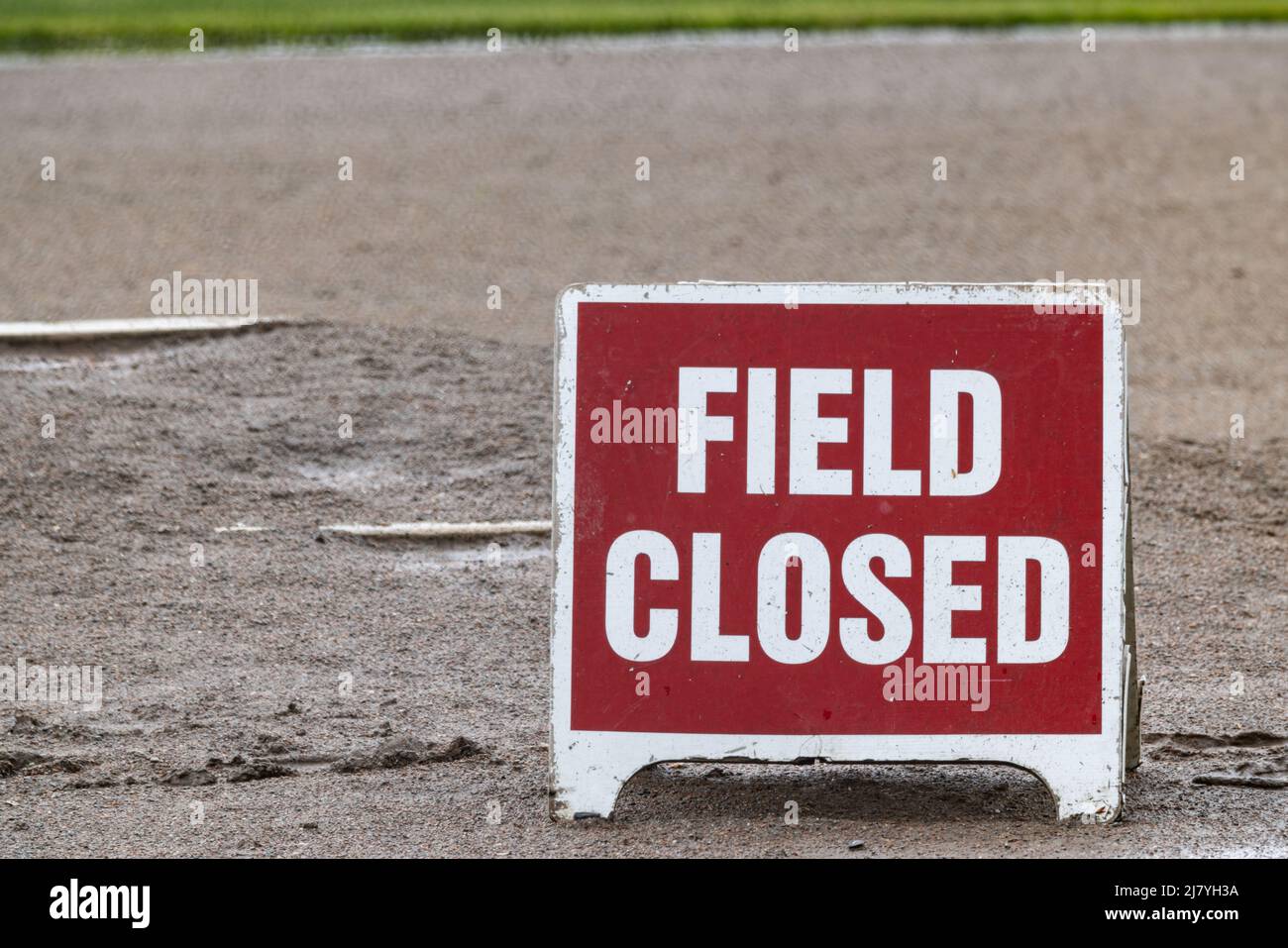 Rot-weißes Schilderlesefeld auf schlammigem Baseballfeld geschlossen. Stockfoto