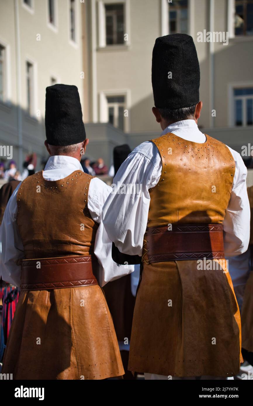 Rückansicht von zwei Männern in Lederkleidung und hohem Hut bei der 366-Grad-Volks-/Religionsprozession von Sant'Efisio in Cagliari Stockfoto