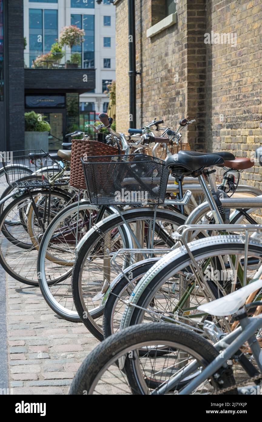 Eine Reihe von verschiedenen Fahrrädern, die an einem Fahrradständer vor der Central Saint Martins Kunstschule in Coal Drops Yard geparkt wurden. London, England, Großbritannien. Stockfoto