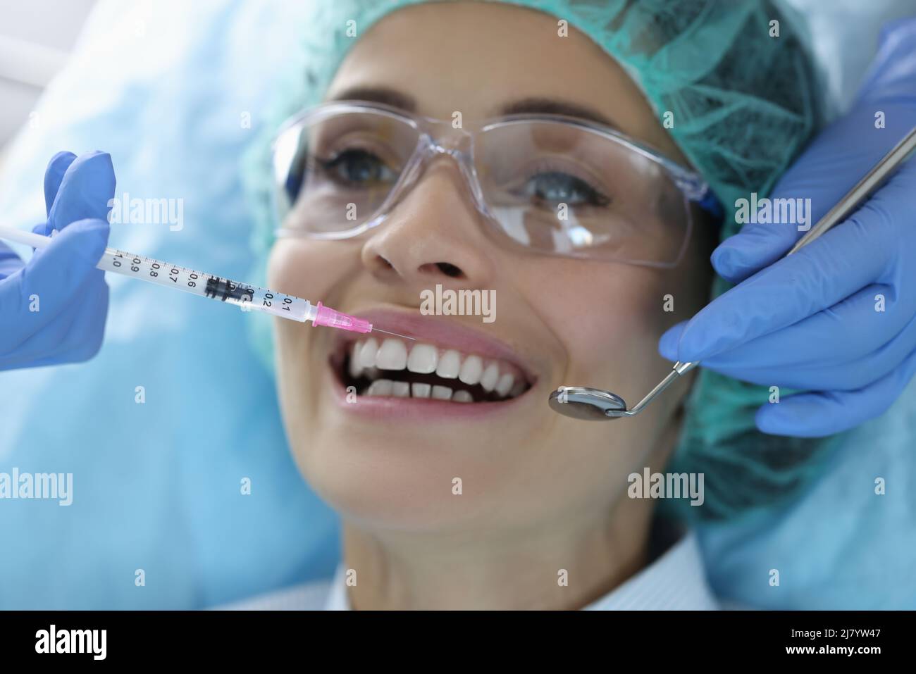 Weibliche Klientin nach Vereinbarung im Stomatologieschrank, Spritze mit Schmerzmittel-Flüssigkeit Stockfoto
