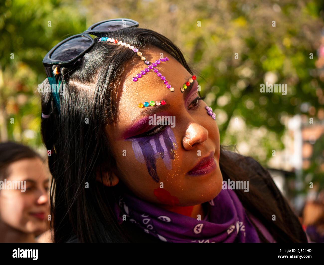 Medellin, Antioquia, Kolumbien - 8 2022. März: Eine junge Frau mit Gesichtsbemalung trägt vor dem Frauenmarsch am Frauentag Make-up auf eine andere Frau auf Stockfoto