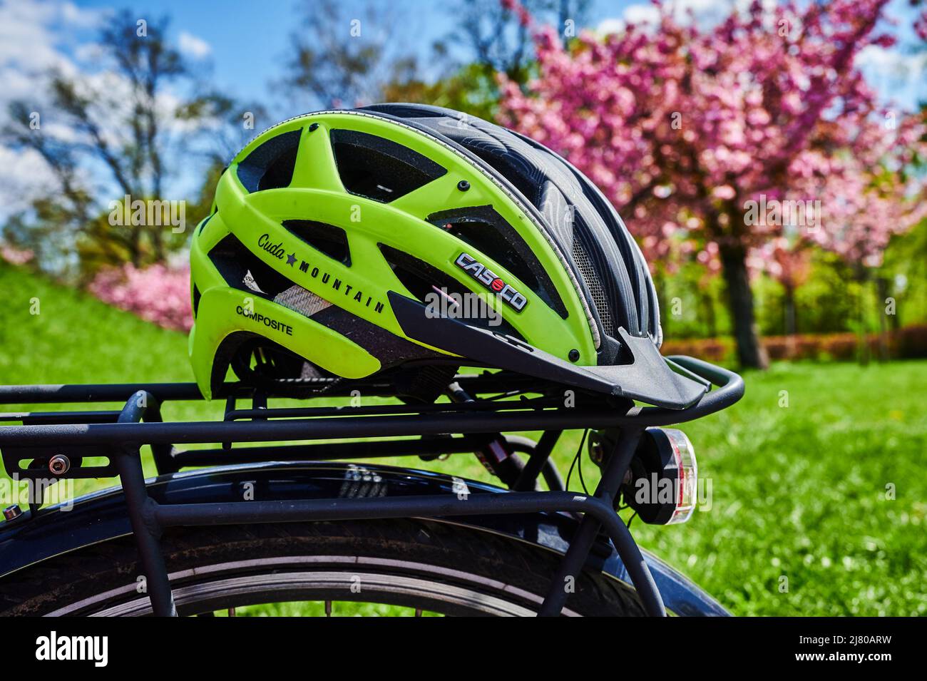 Berlin, Deutschland - 27. April 2022: Gelber Fahrradhelm auf dem Gepäckträger eines Fahrrads. Stockfoto