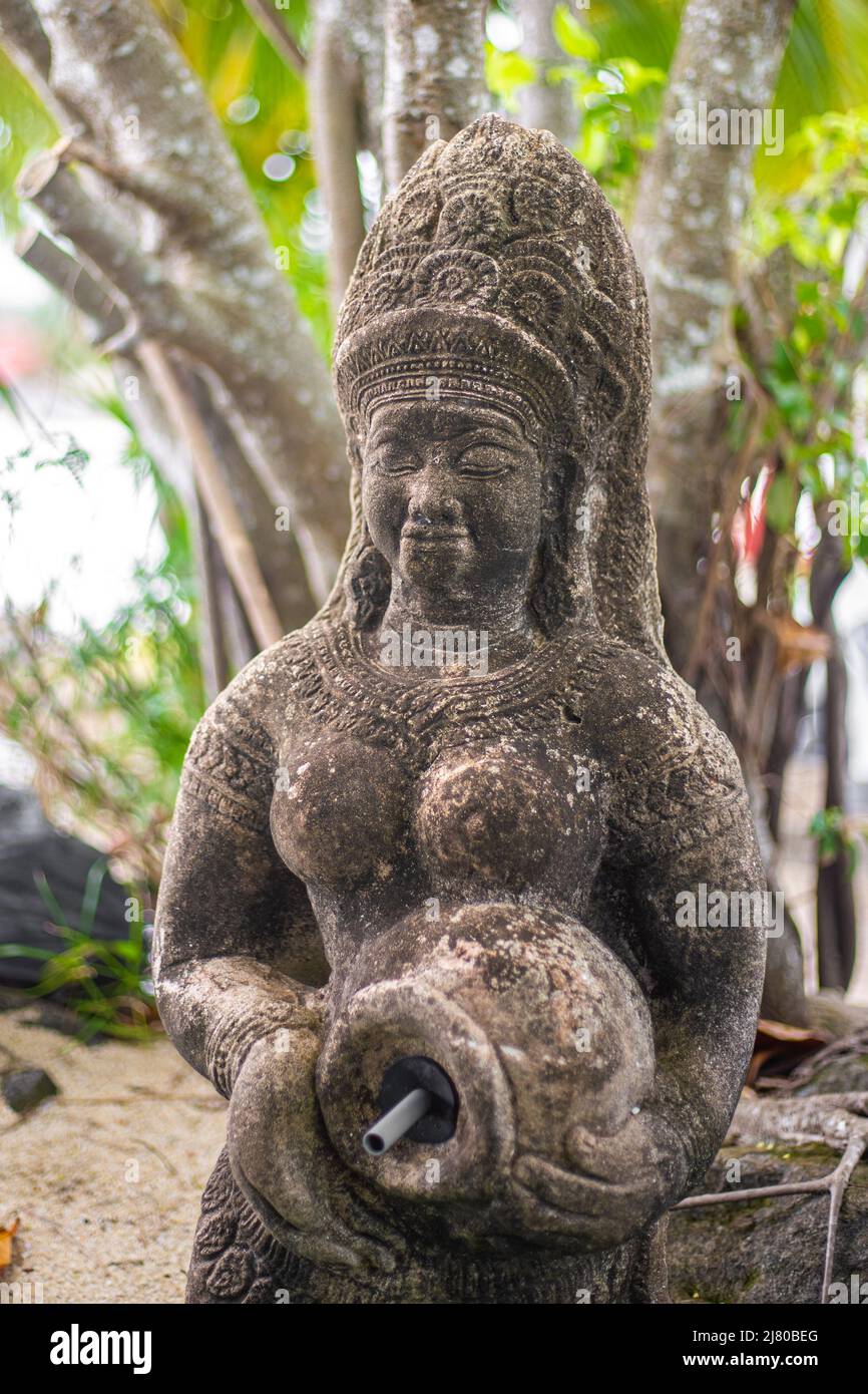 Statue einer Frau in Nationaltracht mit einem Krug in einem tropischen Garten. Asiatische Kultur. Stockfoto
