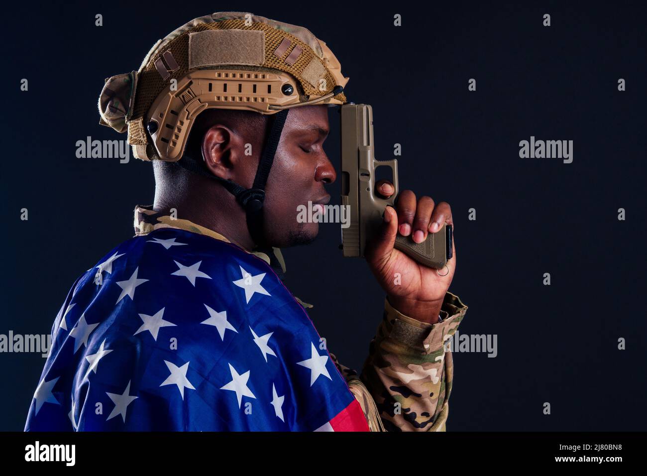 amerikanischer Mann in Tarnanzug mit Pistolenschuss im Studio Stockfoto
