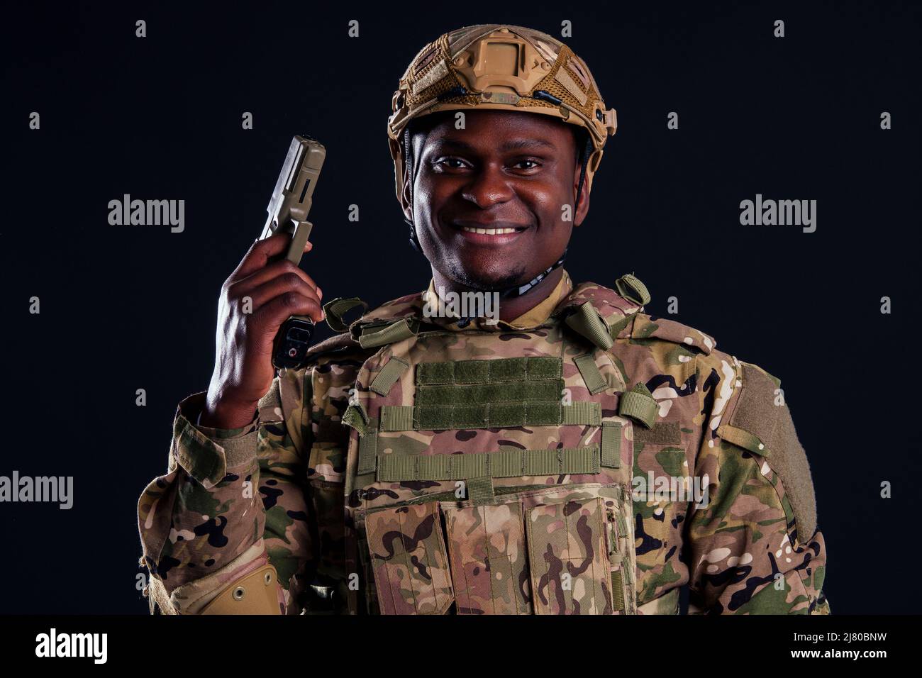 amerikanischer Mann in Tarnanzug mit Pistolenschuss im Studio Stockfoto
