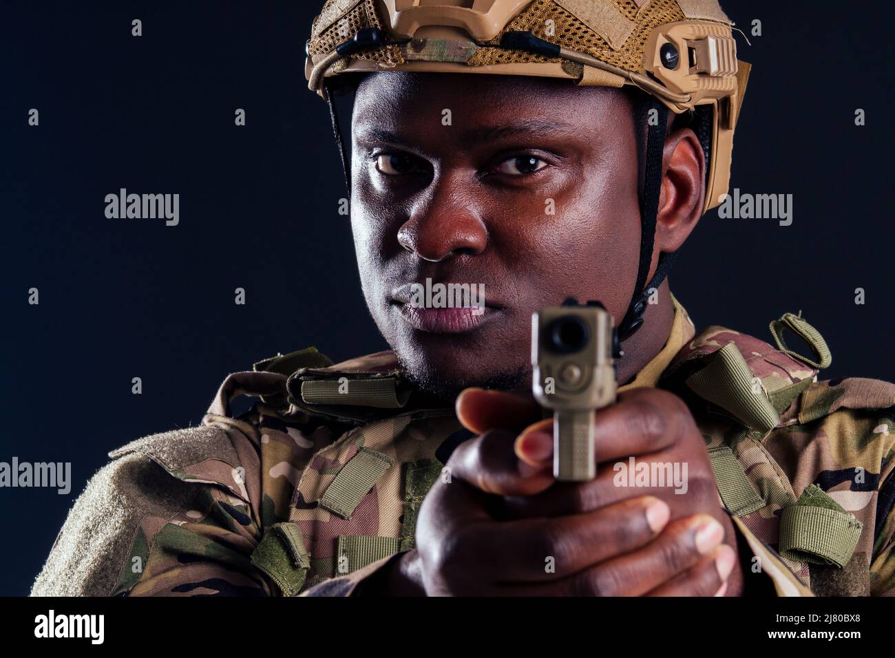 amerikanischer Mann in Tarnanzug mit Pistolenschuss im Studio Stockfoto