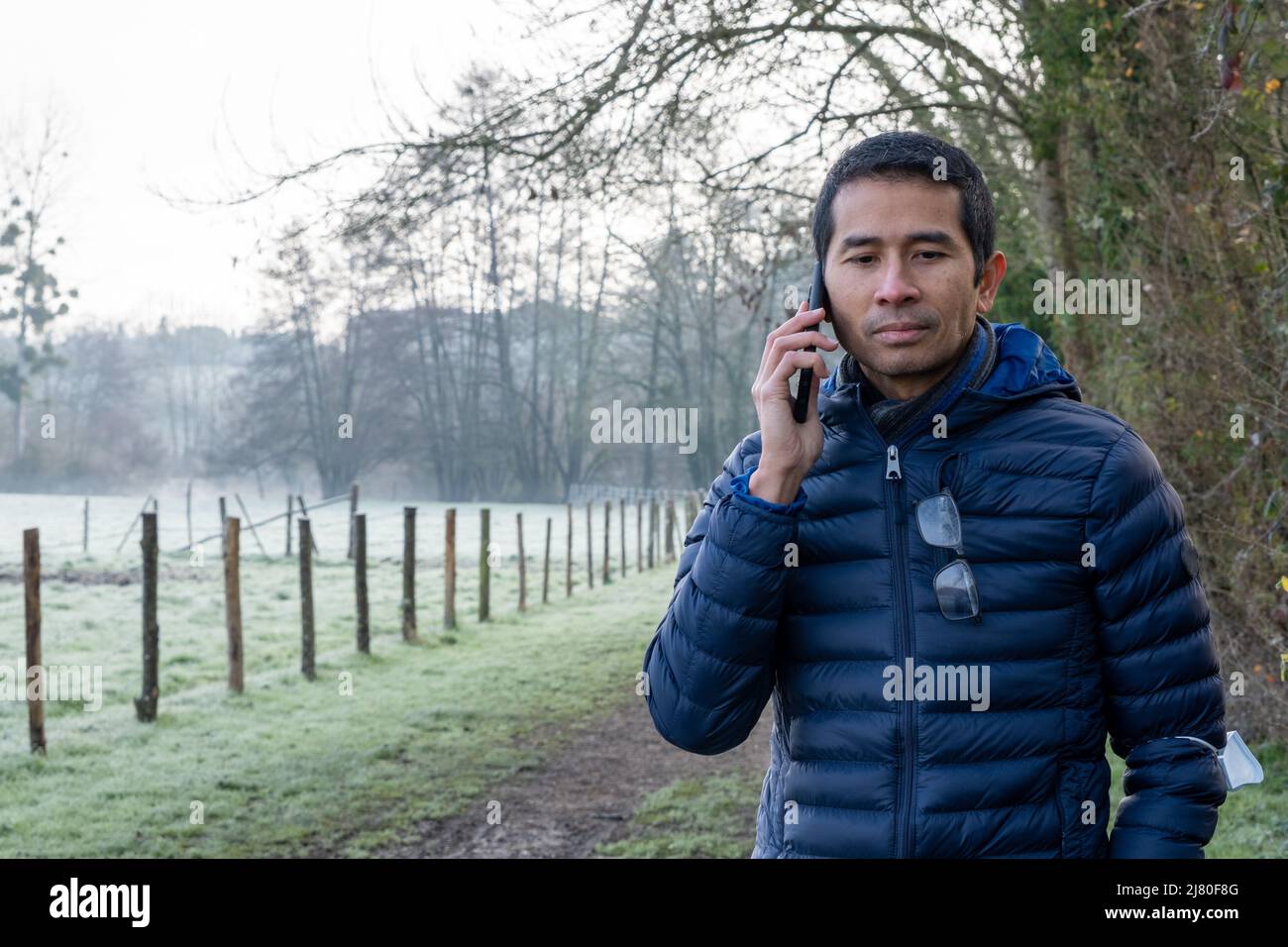 Mann, der in einer ländlichen Landschaft steht und mit dem Mobiltelefon spricht, Chauray, Deux-Sevres, Frankreich Stockfoto