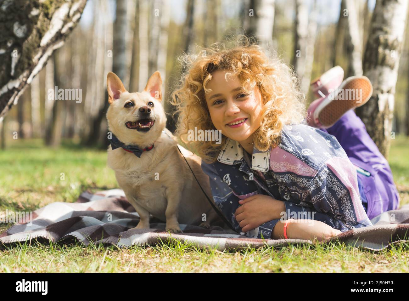 Junge charmante kaukasische Mädchen ruht im Park mit ihrem geliebten Hund voller Schuss im Freien Haustier Konzept. Hochwertige Fotos Stockfoto