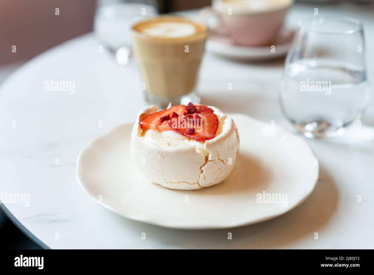 Kaffee, Wasser und Baiser-Kuchen mit frischen Erdbeeren Stockfoto