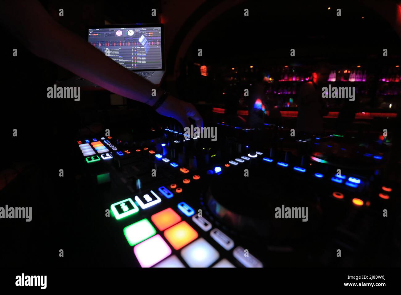 DJ bei der Arbeit in einem Nachtclub mit professioneller Audio-Fernbedienung Stockfoto