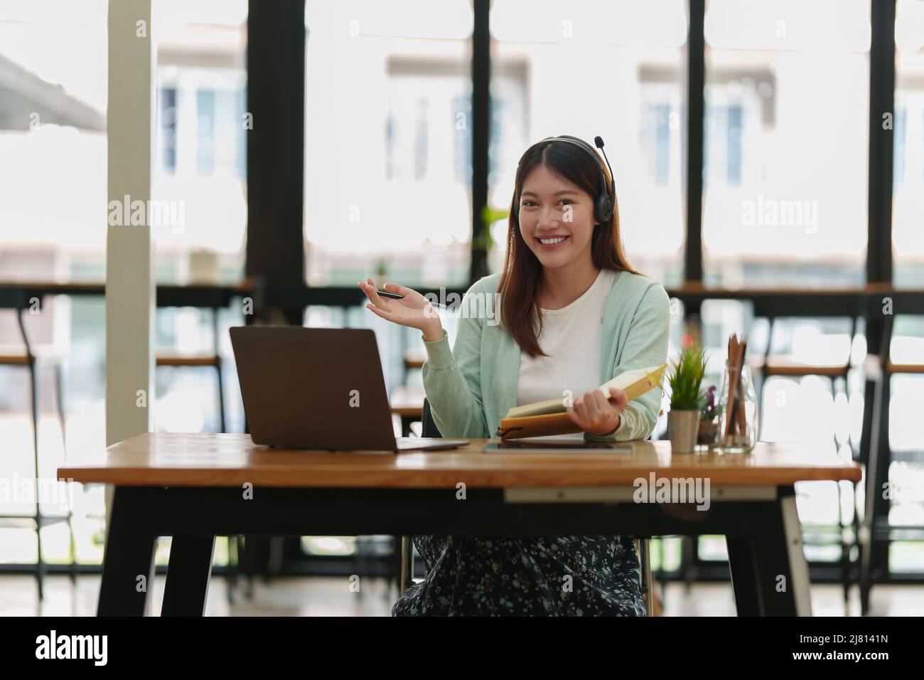 Lächelnder asiatischer aufmerksamer Student studiert Online-Klasse. E-Learning-Bildungskonzept. Stockfoto