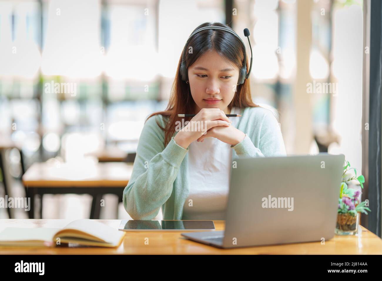Lächelnder asiatischer aufmerksamer Student studiert Online-Klasse. E-Learning-Bildungskonzept. Stockfoto