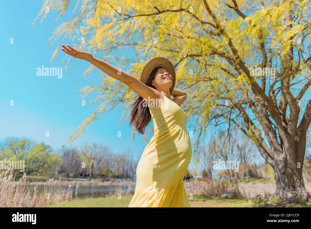 Schwangere glücklich tanzen sorglos im Frühling Natur mit offenen Armen. Asia girl happiness free gesunden Sommer im Freien Schwangerschaft Stockfoto