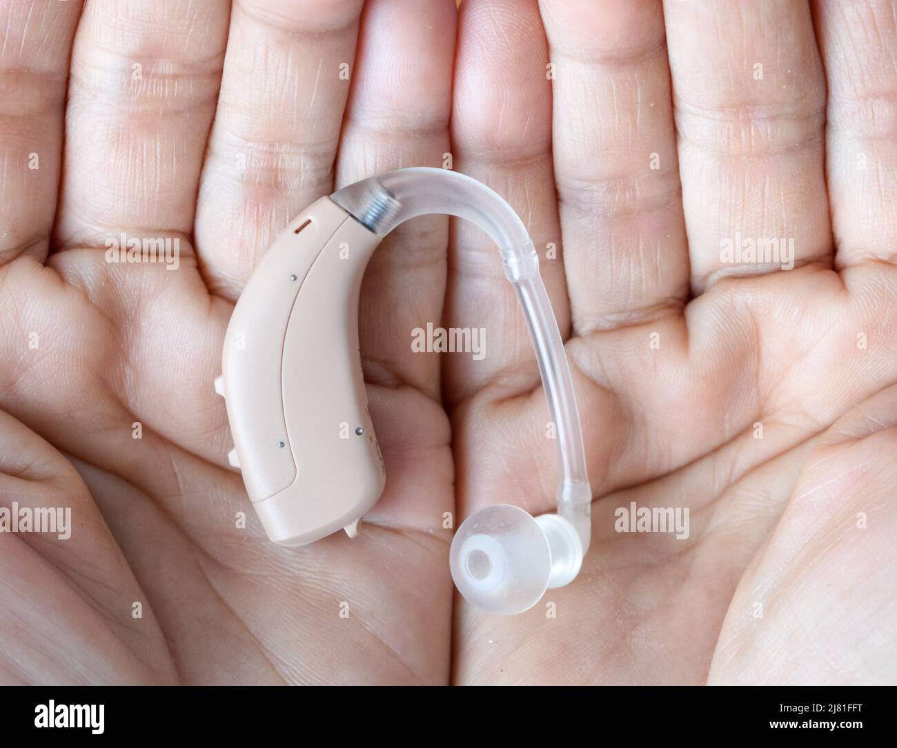 Elektronisches Hörgerät im Ohr einer alten asiatischen Frau mit totaler Taubheit. Stockfoto