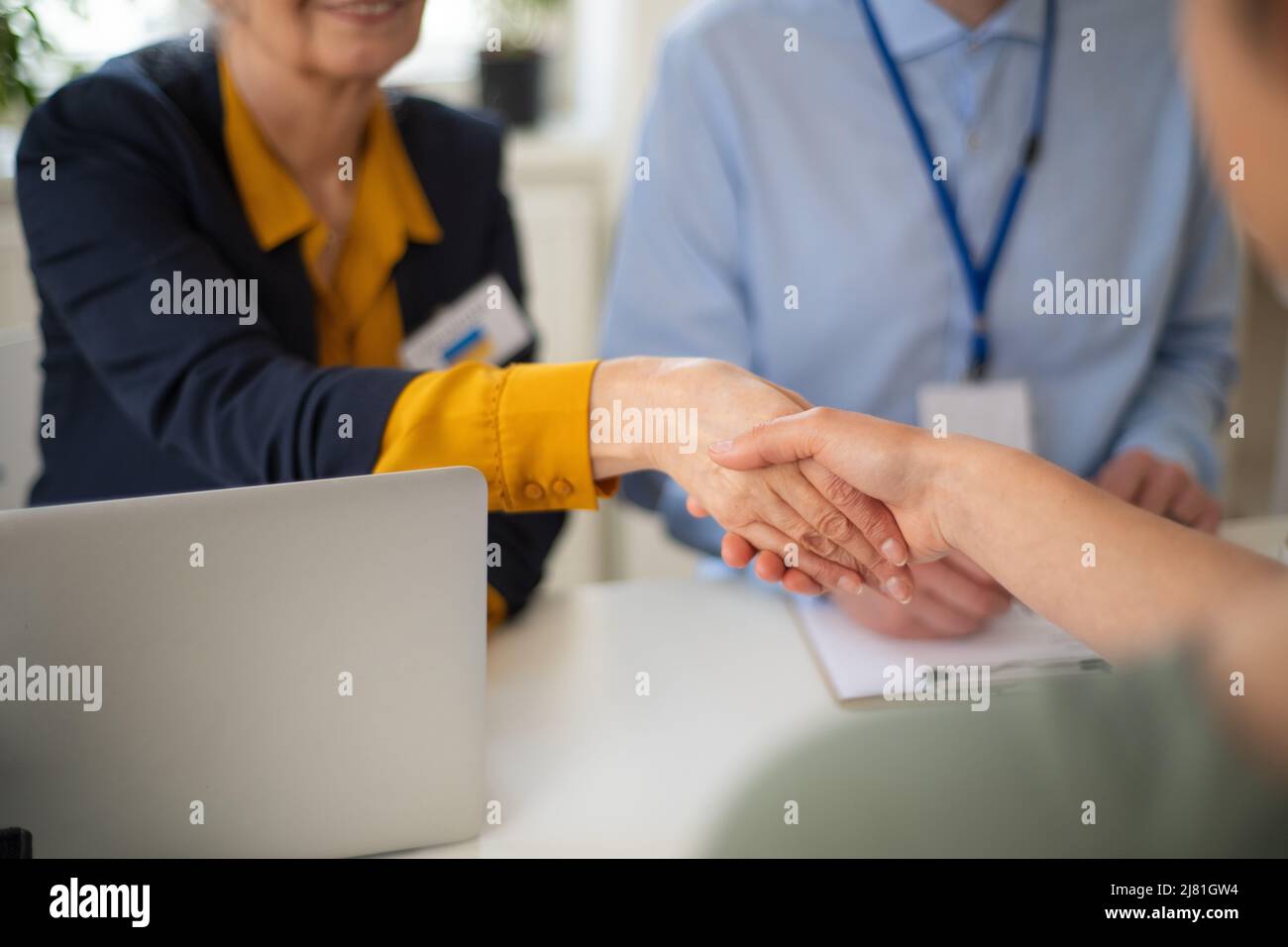 Freiwillige Helferinnen von Frauen und Männern, die der ukrainischen Frau beim Ausfüllen von Formularen im Asylzentrum helfen. Stockfoto