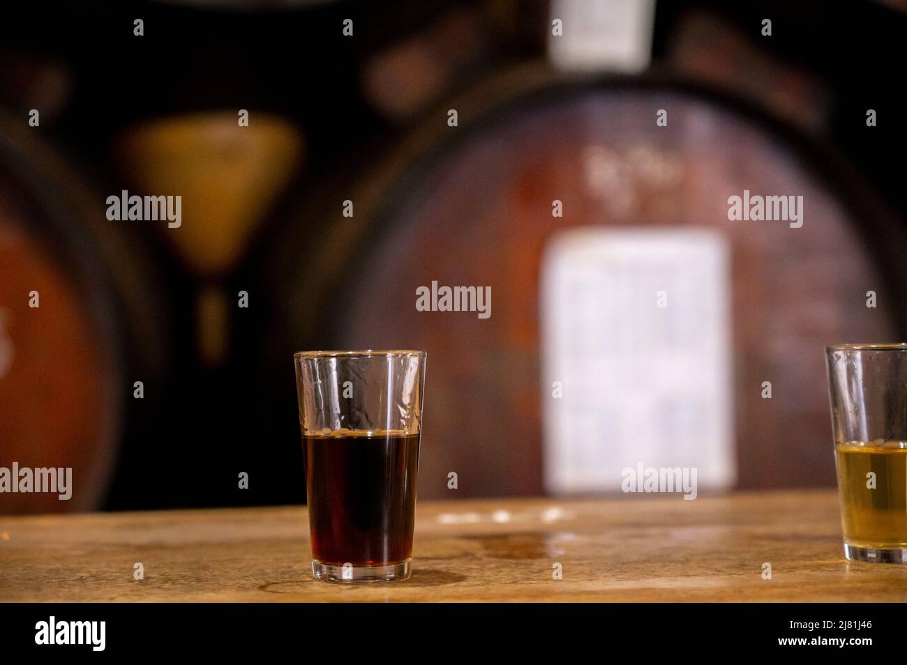 Verkostung verschiedener Süßweine aus Holzfässern auf einer alten Bodega-Weinbar im zentralen Teil von Malaga, Andalusien, Spanien Stockfoto