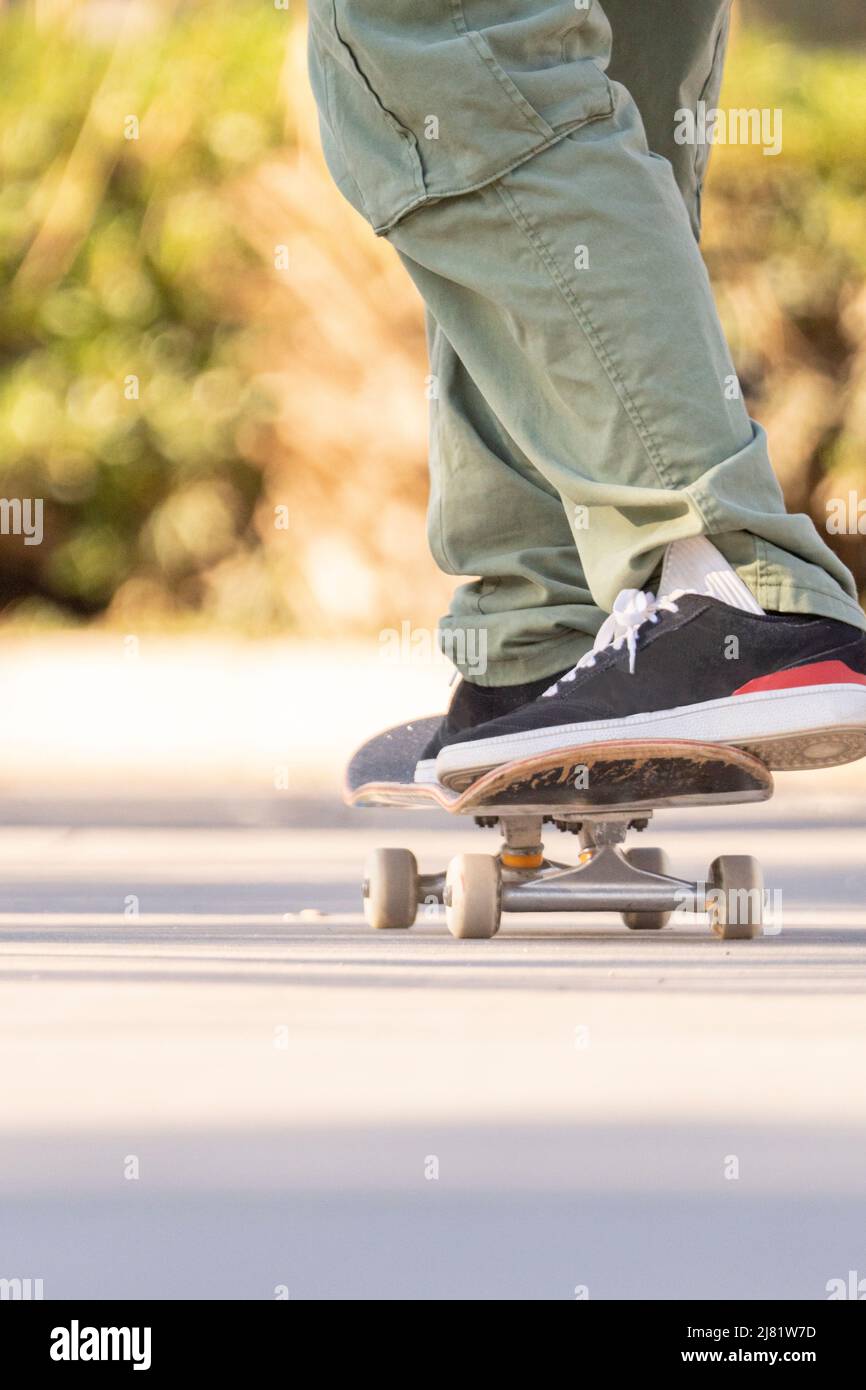 Erwachsener Mann in der Stadt zu Fuß mit seinem kurzen flachen Skateboard Stockfoto