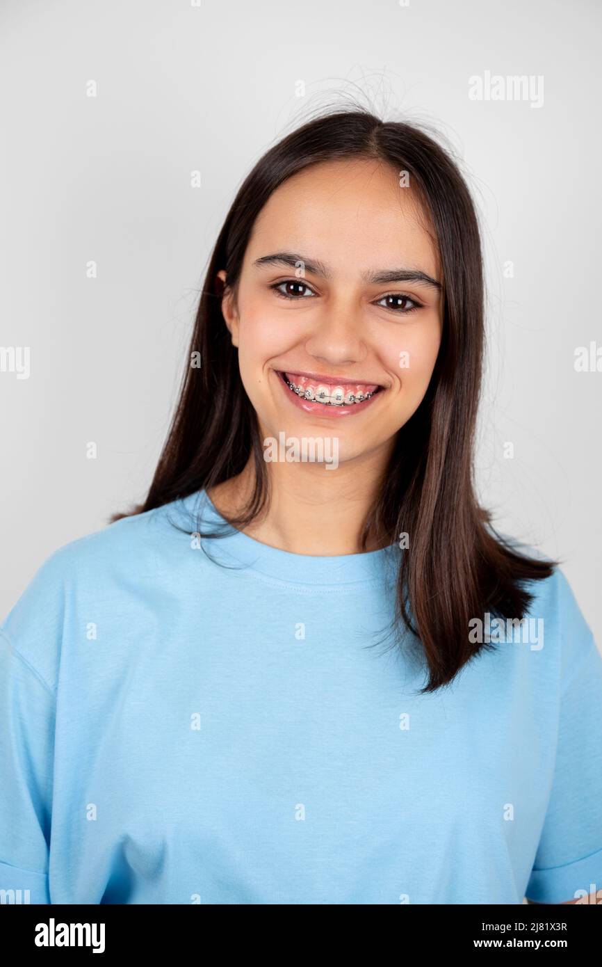 Porträt eines niedlichen und glücklichen Teenager-Mädchen mit Zahnspangen lächelnd. Isoliert auf Weiß Stockfoto