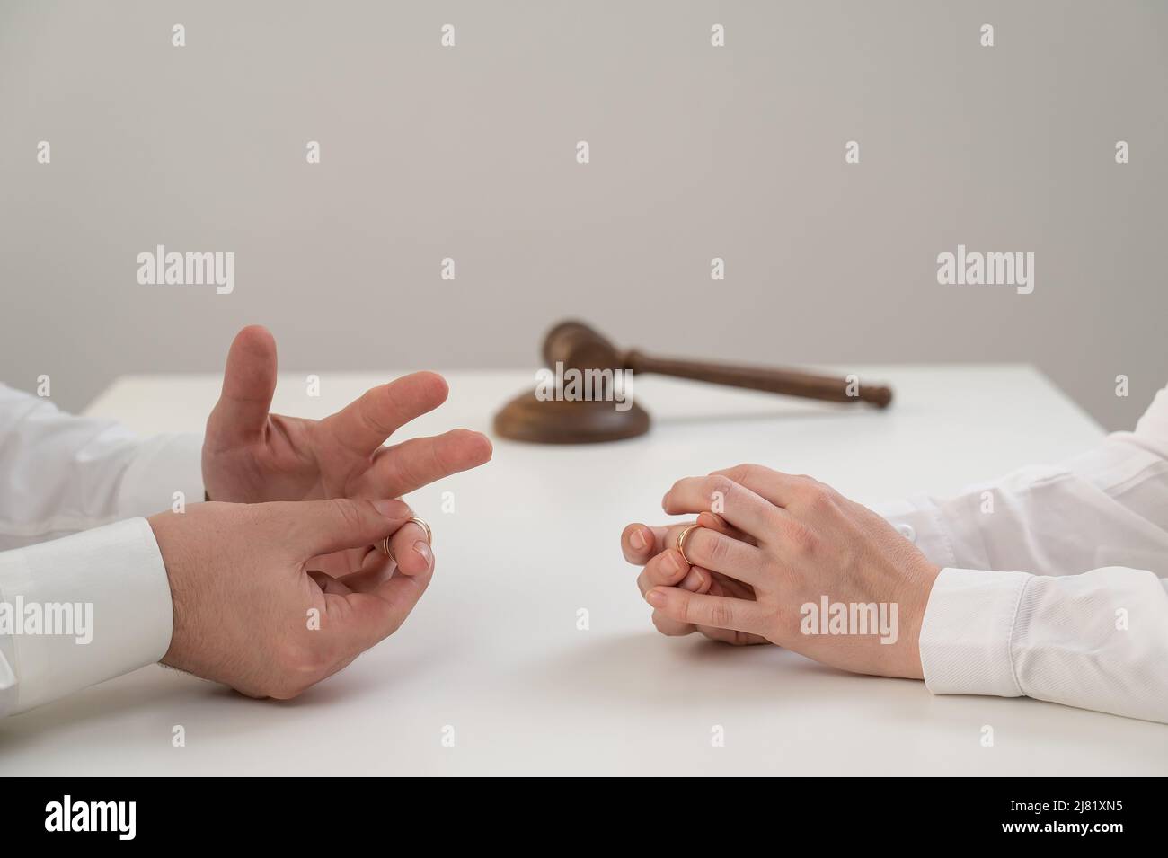 Eine Frau und ein Mann ziehen ihre Eheringe aus. Das Paar wird geschieden. Stockfoto