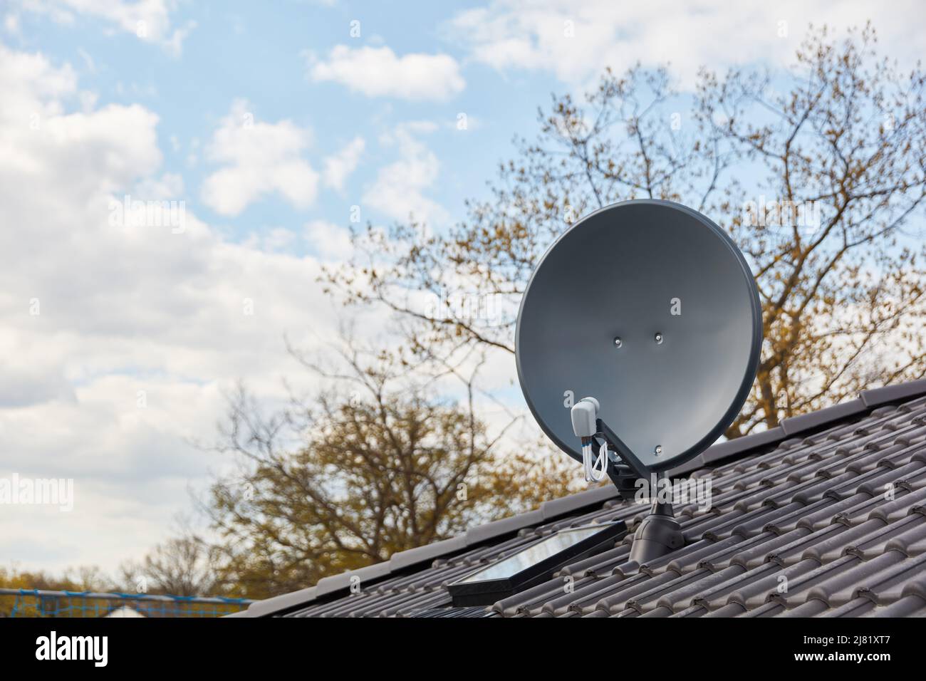 Moderne Satellitenschüssel auf dem Hausdach für digitalen TV-Empfang Stockfoto