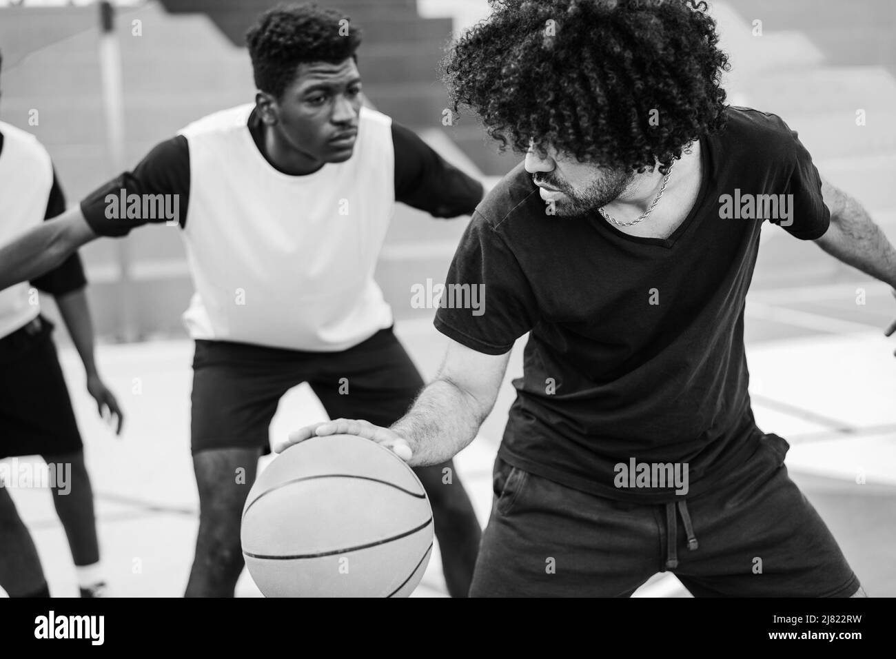 Afrikanische Freunde spielen Basketball im Freien - Weiche Fokus auf rechten Mann Schulter - Schwarz-Weiß-Schnitt Stockfoto