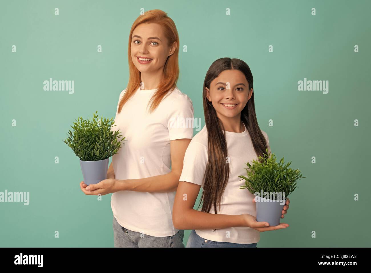 Adoptivfamilie von adoptierten Tochter Kind und Frau Mutter lächeln mit Topfpflanzen, Pflege Stockfoto