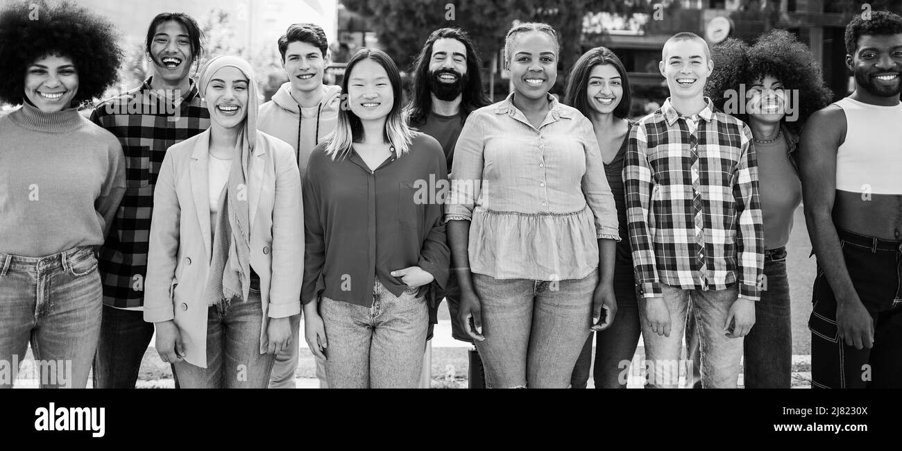 Junge, vielfältige Menschen, die Spaß im Freien haben, lachen zusammen - Fokus auf afrikanisches Mädchengesicht - Schwarz-Weiß-Schnitt Stockfoto