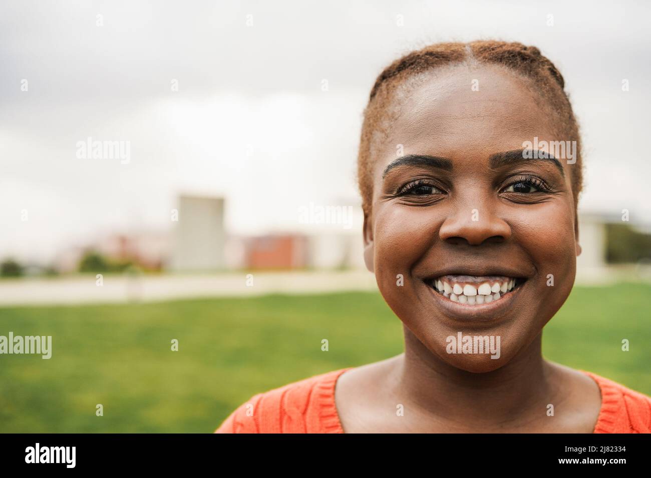 Junge afrikanische Frau lächelt vor der Kamera im Freien - Fokus auf Gesicht Stockfoto
